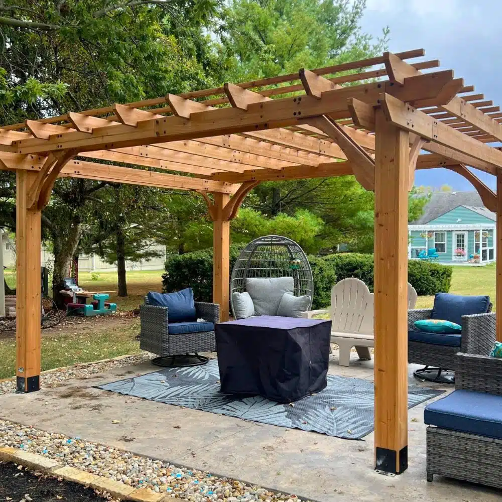 Custom wood pergola installed over backyard patio in Columbus, Ohio, featuring exposed beams, outdoor seating area, and landscaped yard