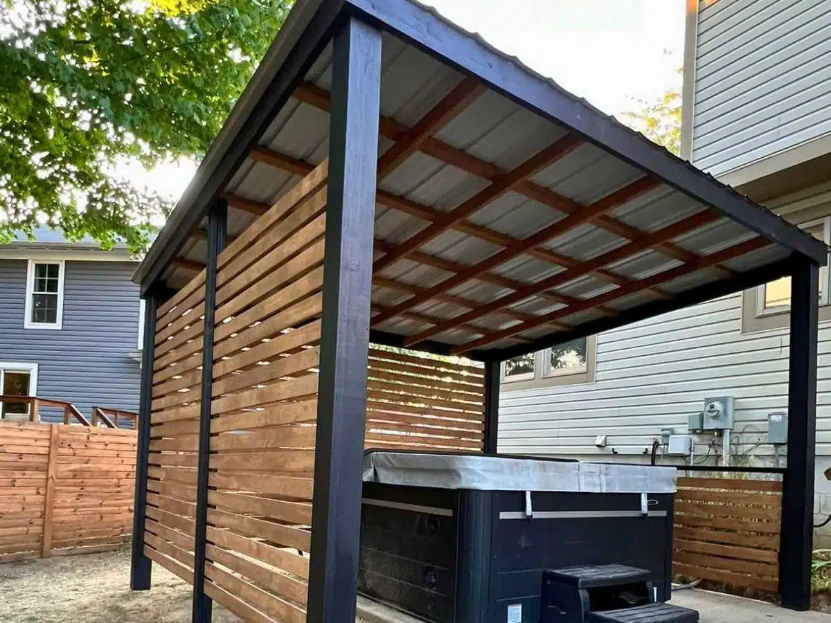Modern gazeb with privacy wall and metal roof installed over an outdoor hot tub area