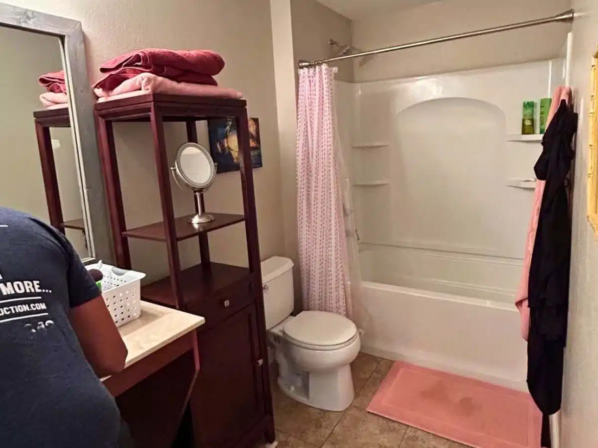 Outdated bathroom before remodeling - dark wood vanity - bathtub shower combo - toilet and pink decor - Columbus Ohio