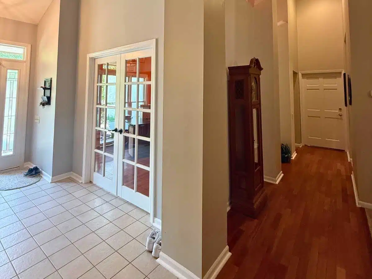bright entry hallway with gray painted walls white French doors and hardwood flooring