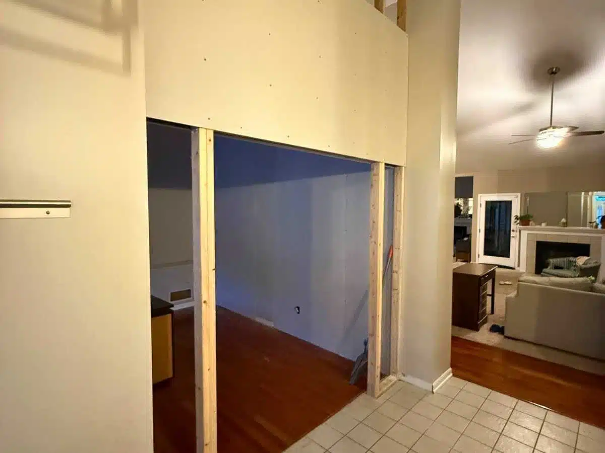 framed opening for new room construction with unfinished drywall and exposed studs in the main living area