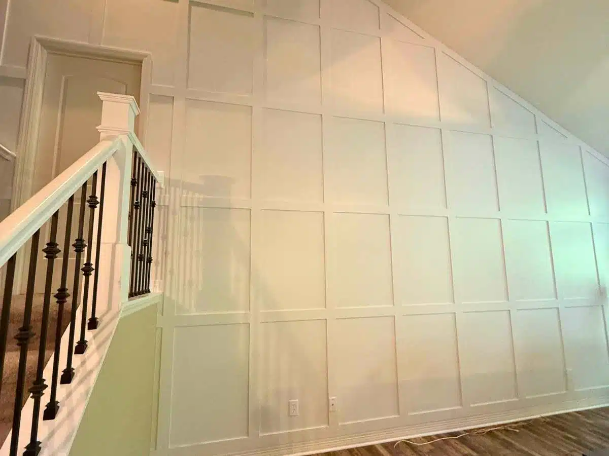 Finished white board and batten accent wall beside an interior staircase
