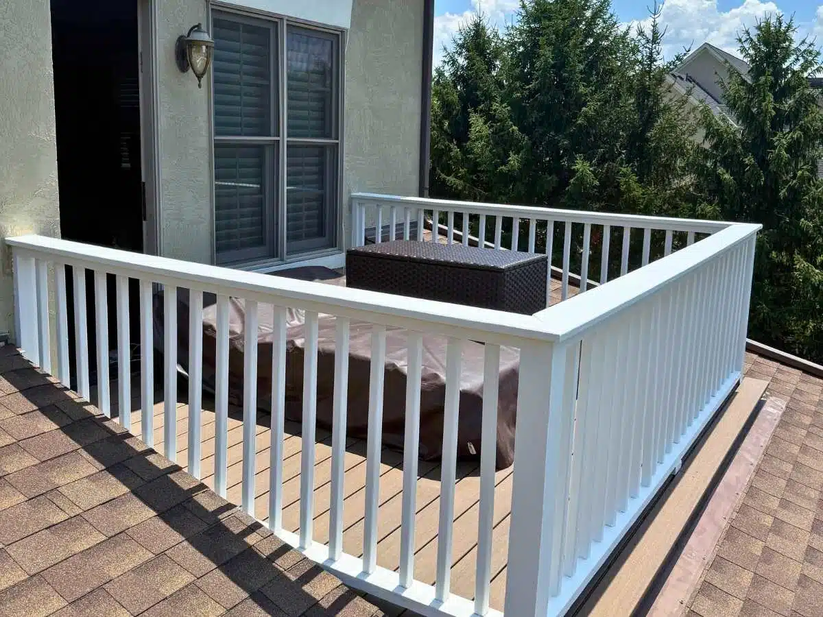 Rooftop deck with composite flooring and newly installed white railing